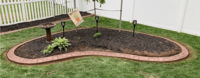 garden with bird feeder and curbed border