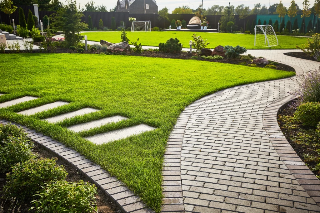 Curved paver walkway design with landscaped lawn and outdoor pathway installation